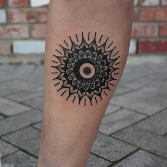Tattoo of a mandala with a crescent moon in the center