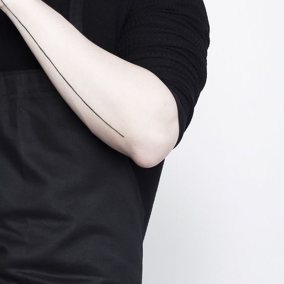 Thin black line tattoo on the forearm