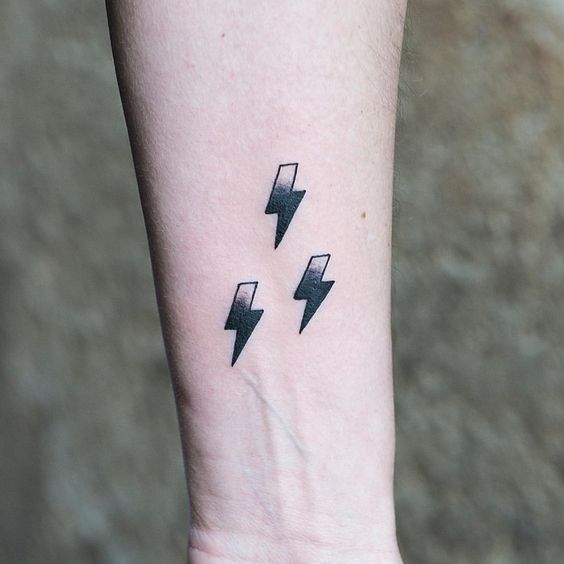 Three lightning symbols tattoo on the arm