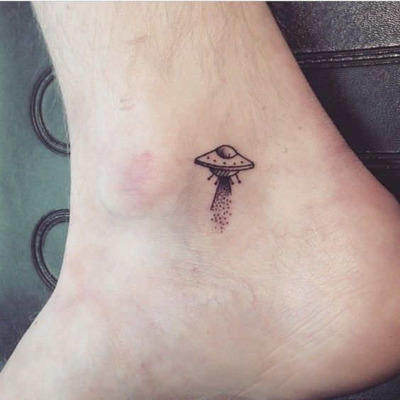 Tiny alien spaceship tattoo on the ankle