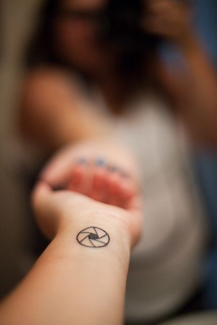 Tiny aperture tattoo on the wrist