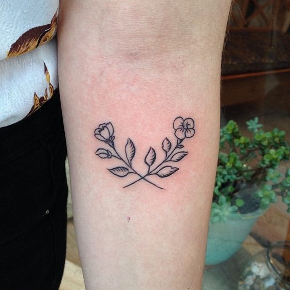 Tiny flowers tattoo on the arm by Candi Kinyobi