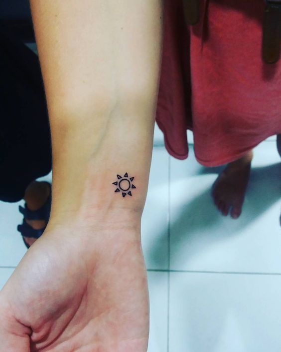 Tiny sun tattoo on the wrist