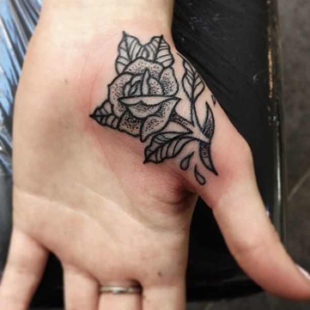 Traditional black rose tattoo on the inner hand