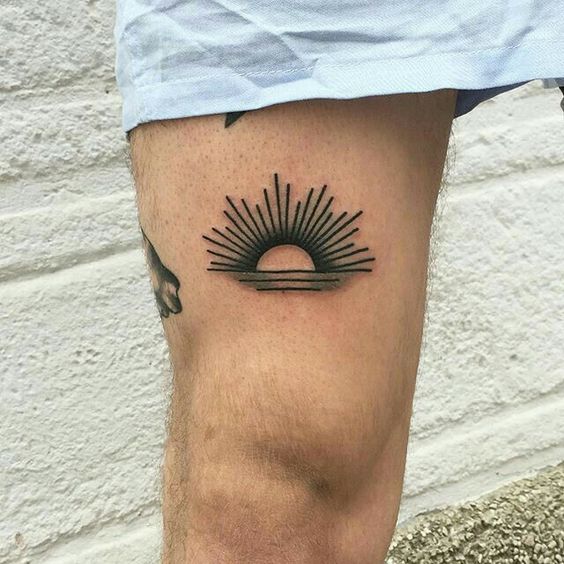 Traditional style small sun tattoo on the thigh