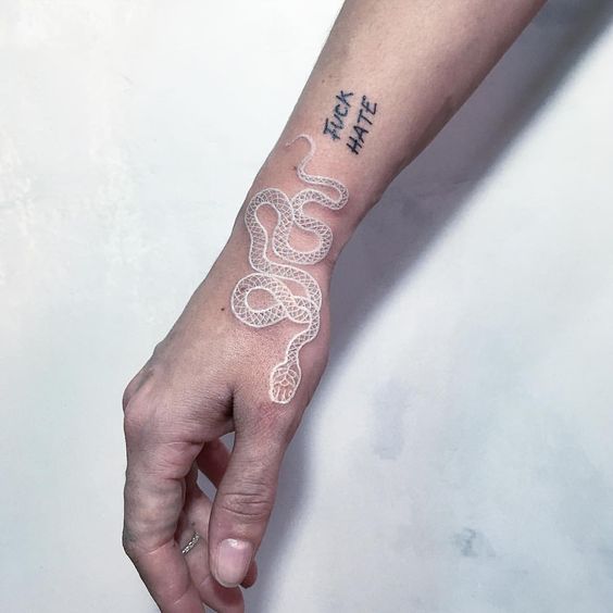 White snake tattoo over the wrist and the hand