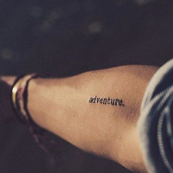 Word adventure tattoo on the arm