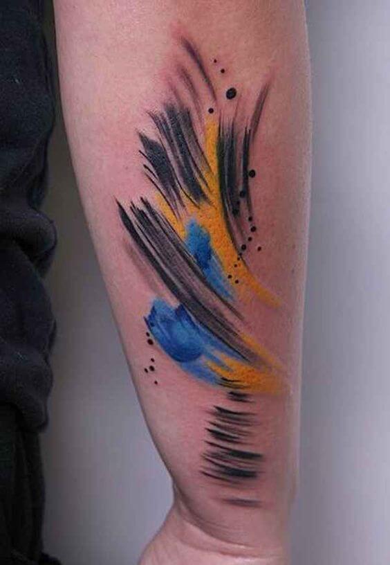 Black yellow and blue abstract tattoo on the forearm