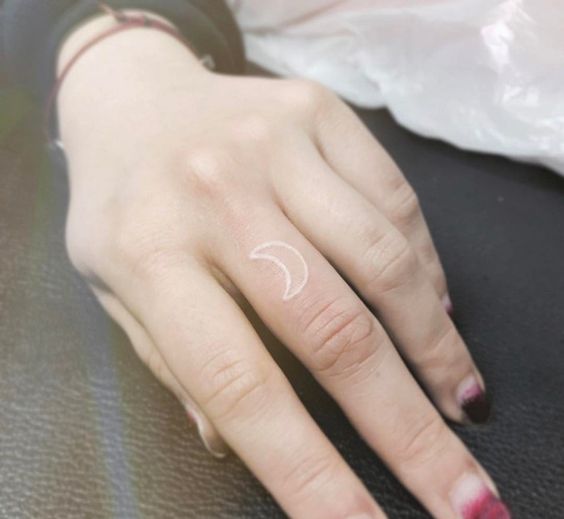 Crescent moon tattoo in white by tattooist Karin