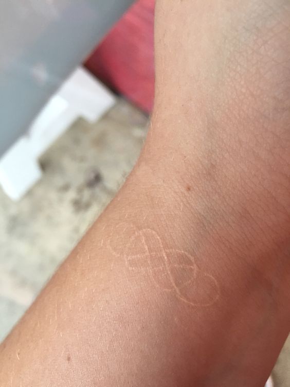Double infinity white tattoo on the wrist