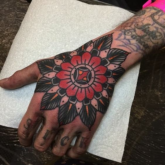 Red mandala tattoo on the hand