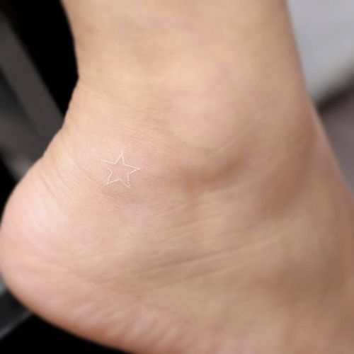 Small white star tattoo on the ankle by tattoo artist Mini Lau