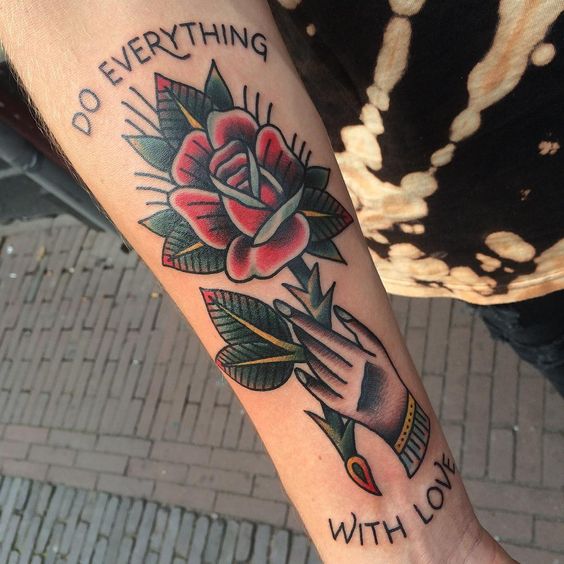 A hand holding rose tattoo with words do everything with love