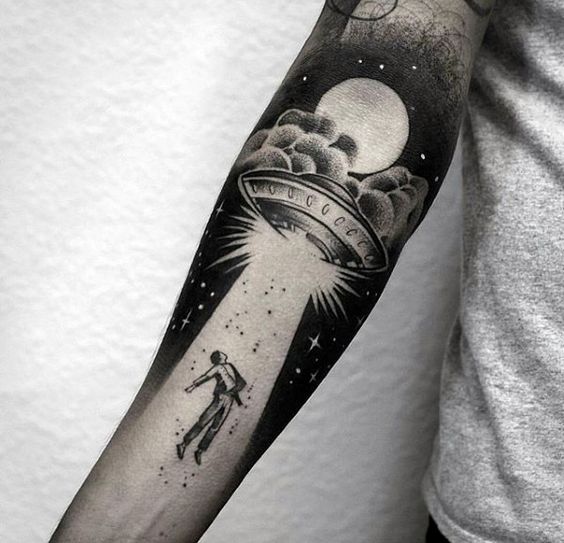 Alien abduction scenery negative space tattoo on the right arm