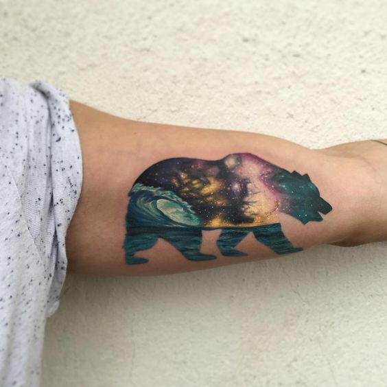 Bear with cosmic landscape tattoo on the left bicep