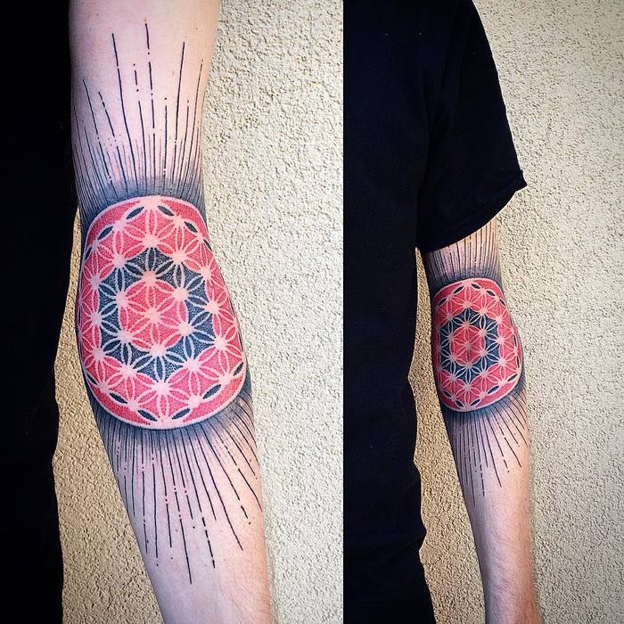 Black and red flower of life tattoo with beams on the left arm