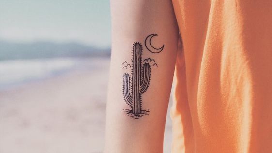 Black cactus and crescent moon tattoo on the right arm
