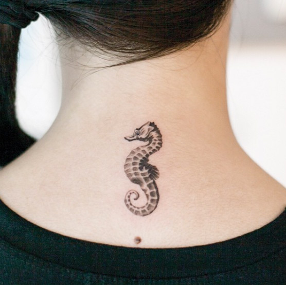 Black dotwork style seahorse tattoo on the back of the neck