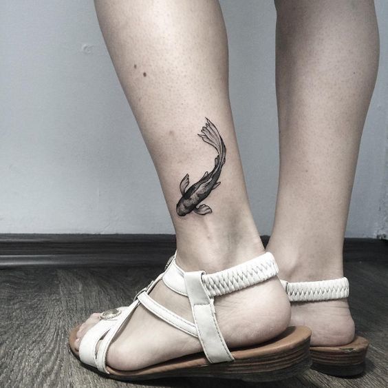 Black fish tattoo on the left ankle