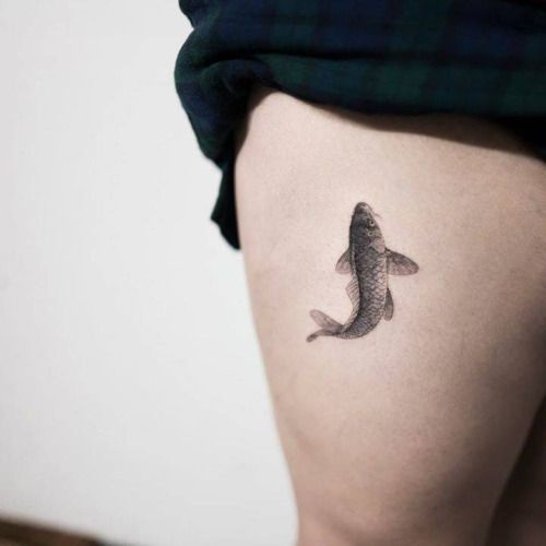 Black fish tattoo on the right thigh