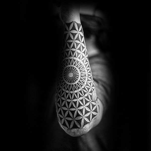 Black flower of life tattoo on the left forearm