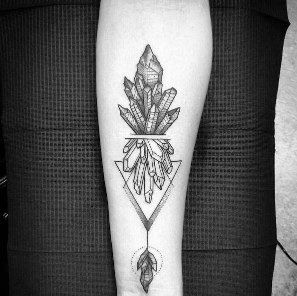 Black geometric crystal tattoo on the right inner arm