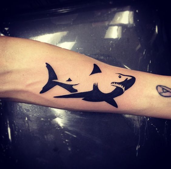 Black negative space shark tattoo on the arm by isaiah negrete