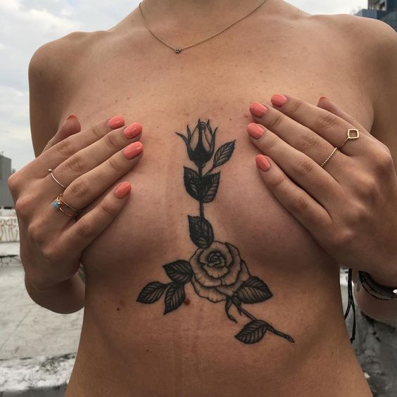 Black rose on sternum and under the left breast