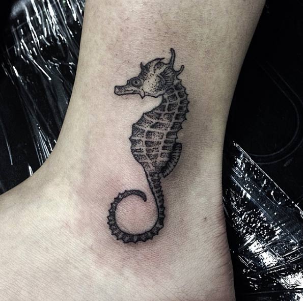 Black seahorse tattoo on the left outer ankle