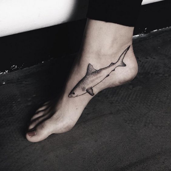 Black shark tattoo on the inner side of the right foot