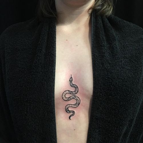 Black snake tattoo on the sternum