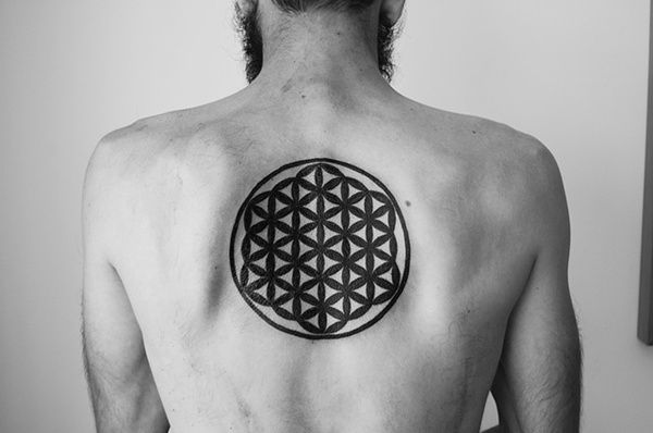 Black solid flower of life tattoo on the upper back