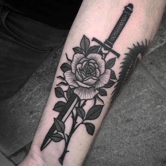 Black sword tattoo with a rose on the left inner wrist