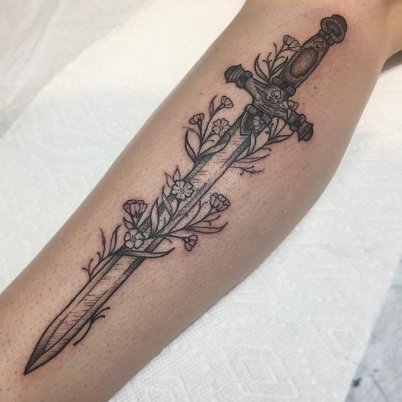 Black sword tattoo with flowers on the left calf