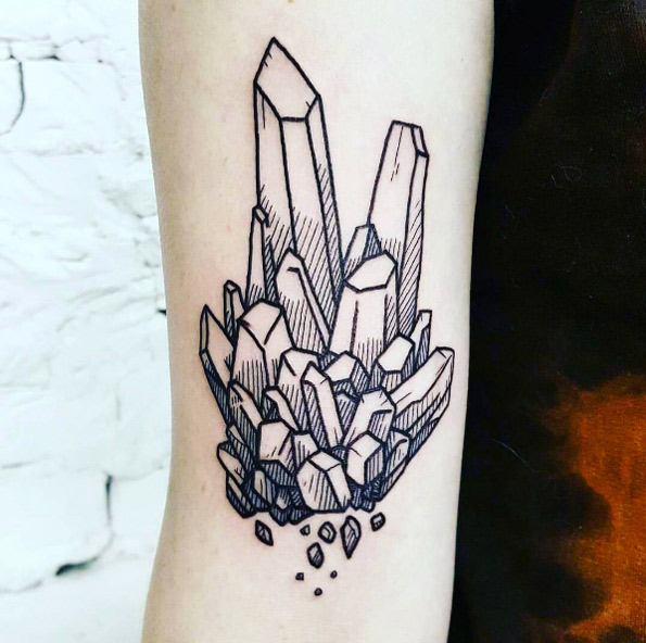 Black tattoo of a clear quartz crystal on the arm