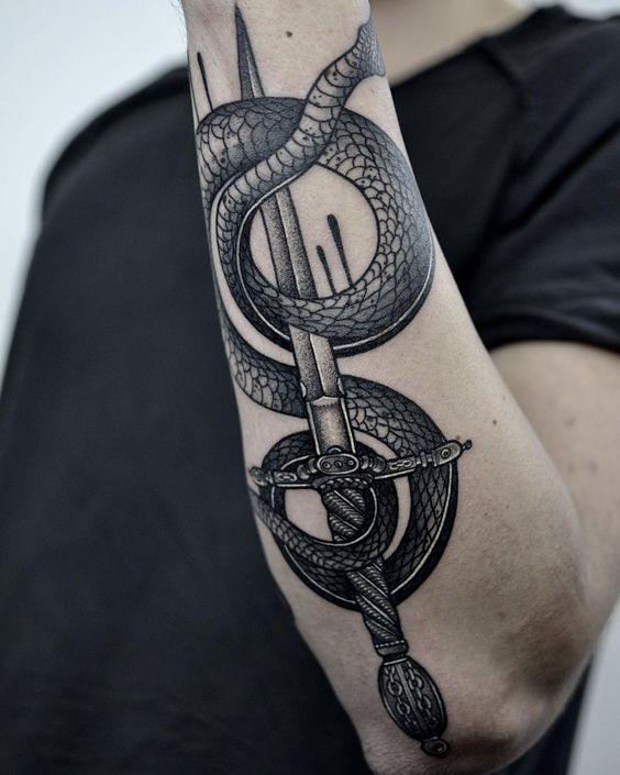 Black work sword and snake tattoo on the left forearm