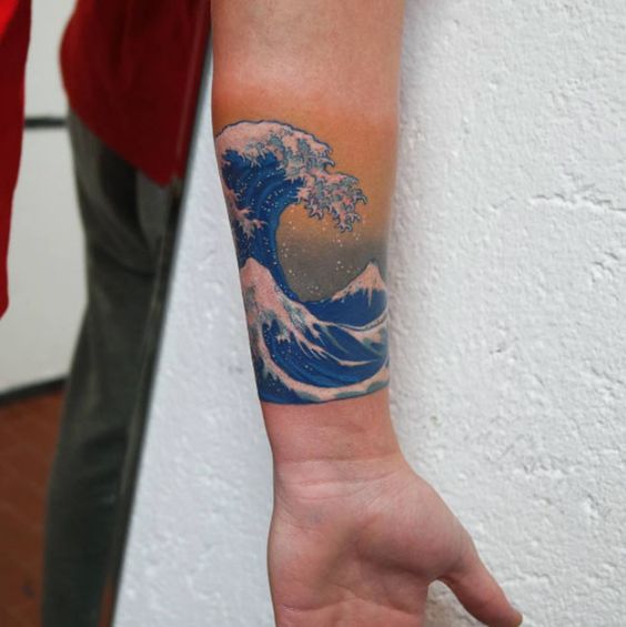 Blue hokusai wave tattoo on the left wrist