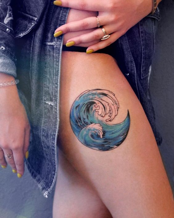 Blue wave tattoo in a circle on the right thigh