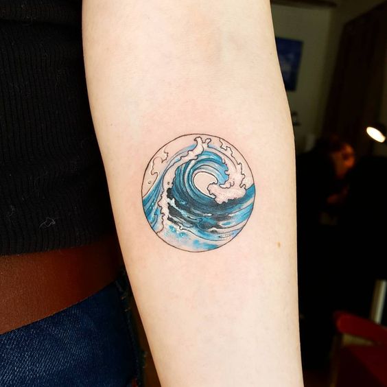 Circular blue wave tattoo on the left inner arm