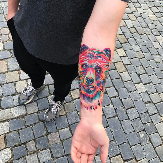 Colorful bear head tattoo on the left arm