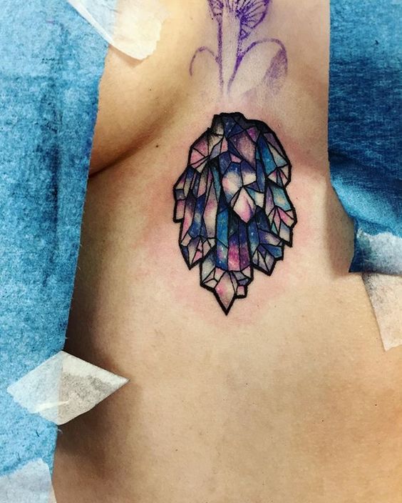 Colorful crystal tattoo on the breastbone
