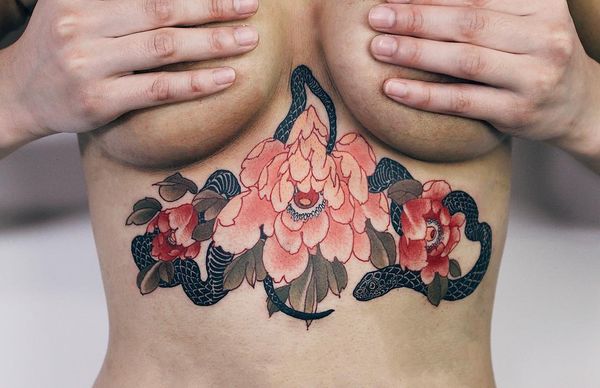 Colorful flowers and snake tattoo on the sternum
