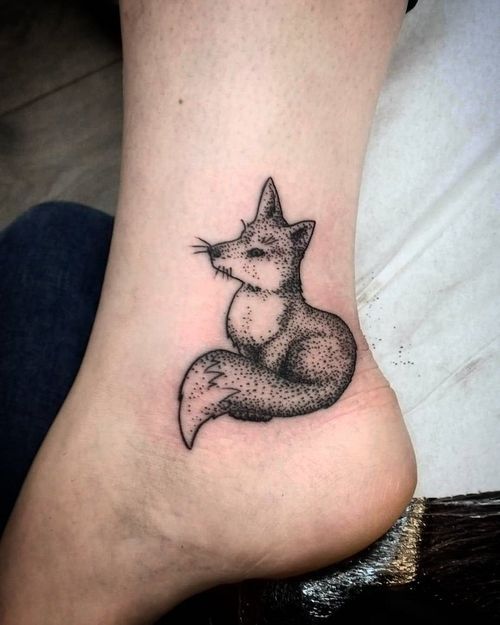 Dotwork black fox tattoo on the left outer ankle