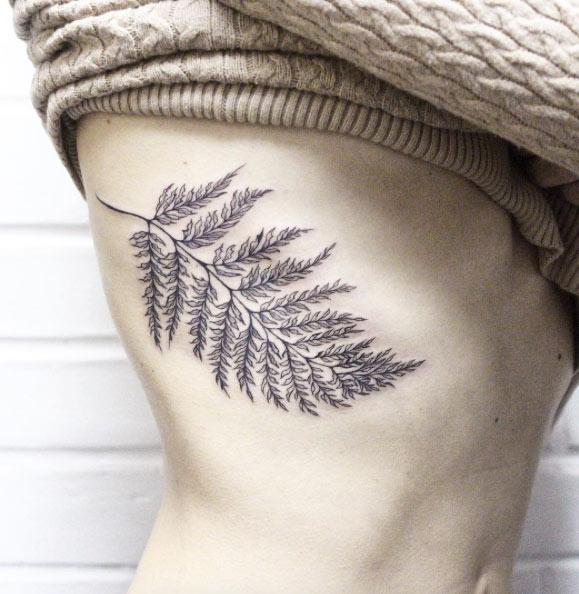 Fern leaf tattoo on the right rib cage