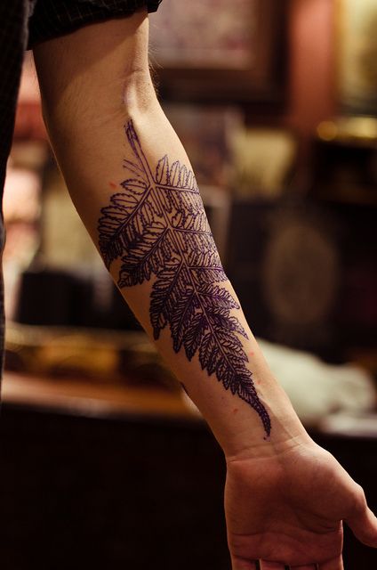 Fern tattoo on the left inner arm