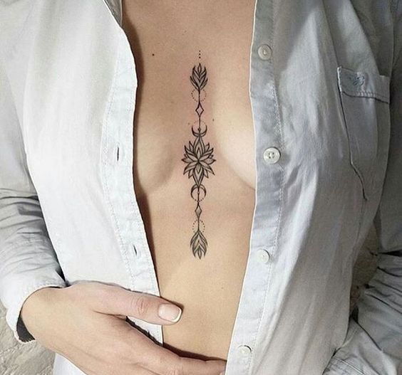 Floral arrow tattoo on the sternum