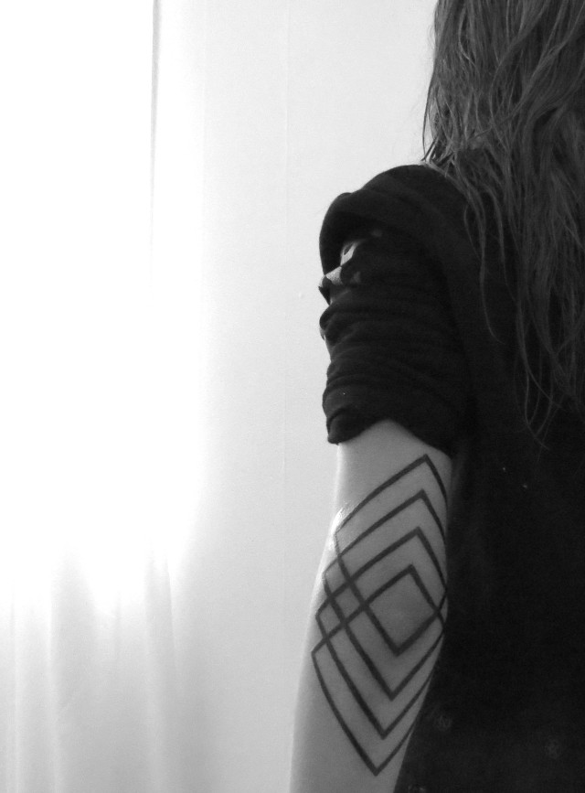 Geometric black tattoo on the left elbow