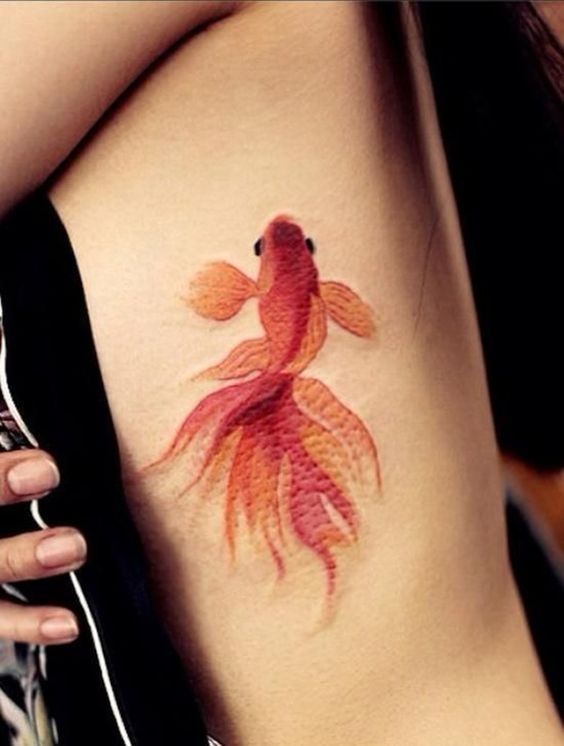 Goldfish tattoo on the left rib cage