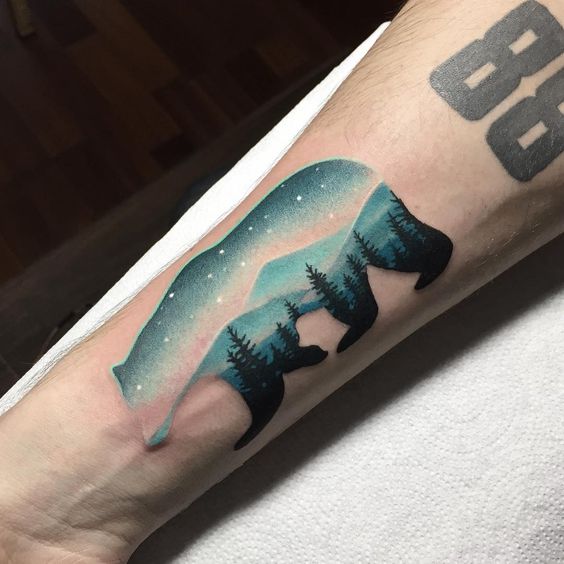 Gorgeous bear with arctic night landscape tattoo on the right arm