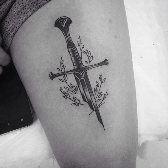 Half sword with flowers tattoo on the left thigh